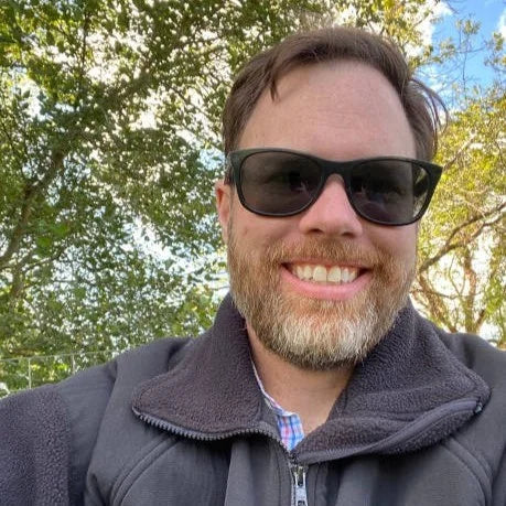 files/1762414705-imgi_1_selfie-of-a-middle-aged-man-sitting-under-trees_1.webp